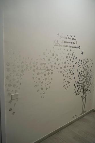 a wall mural of a tree with birds at La Stazione Sabina Alloggio Turistico in Stimigliano