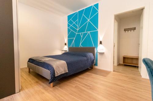 a bedroom with a bed and a blue wall at Fiera house Bologna in Bologna