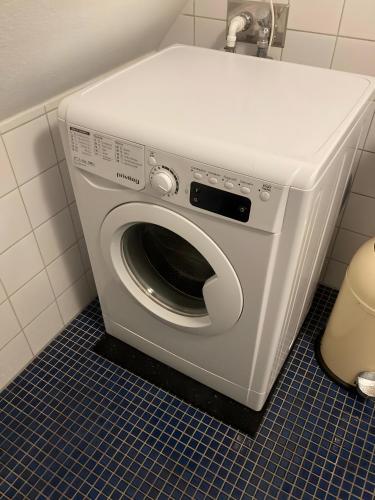 a washing machine in a bathroom with a toilet at Alte Schmiede Ellrichshausen 2 in Satteldorf