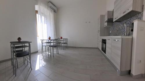 a kitchen with tables and chairs in a room at La Stazione Sabina Alloggio Turistico in Stimigliano