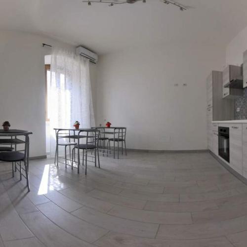 a room with a table and chairs and a kitchen at La Stazione Sabina Alloggio Turistico in Stimigliano