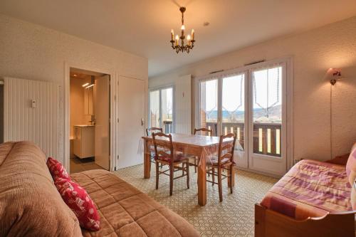 - une chambre avec une table et des chaises ainsi qu'une salle à manger dans l'établissement Lans en Vercors Studio 2 pièces, à Lans-en-Vercors