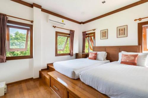 two beds in a bedroom with two windows at Thai Villa Melitta Bangrak Bohput, Beach, Pool, SeaViews, 6-enSuite, Full Villa, Luxury, AAA Location Koh Samui in Bang Rak Beach