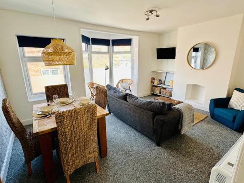 a living room with a table and a couch at Beautiful apartment, moments from the sea in Weymouth