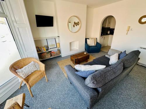 a living room with a blue couch and chairs at Beautiful apartment, moments from the sea in Weymouth