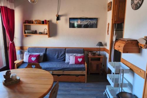 un salon avec un canapé bleu et une table dans l'établissement Cozy Apartment with Balcony Saint-Gervais, à Saint-Gervais-les-Bains