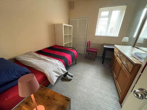 a bedroom with two beds and a desk and a table at Single room 10 minutes to Central London in London