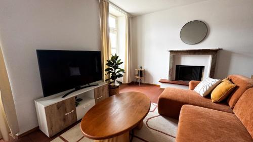 a living room with a couch and a table and a television at Piazza Grande Duplex in Locarno