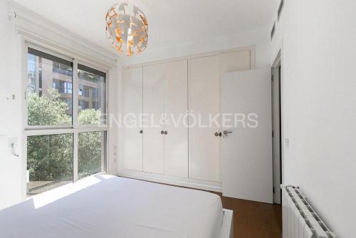 a white bedroom with a bed and a window at HomeSweetHome Valencia in Valencia