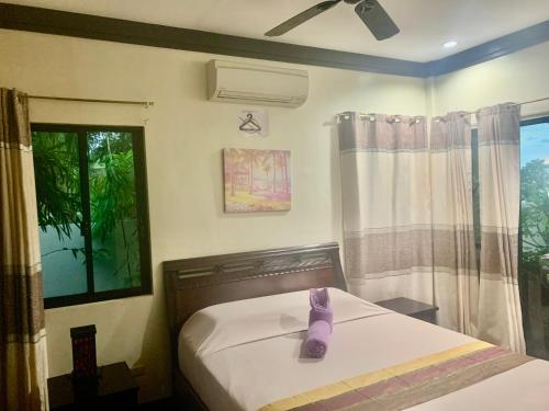 a bedroom with a bed with a pair of purple shoes on it at Adayo Cove Resort in Siquijor