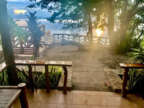 a table and benches in front of the ocean at Adayo Cove Resort in Siquijor