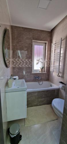 a bathroom with a tub and a sink and a toilet at Noszvaj Vendégház in Noszvaj