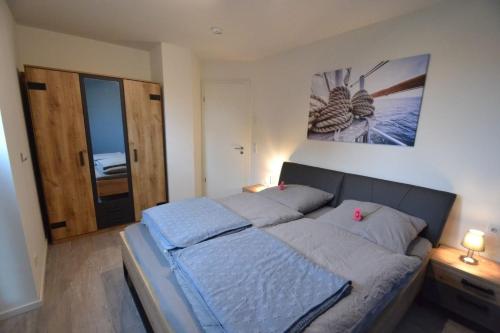 1 dormitorio con 1 cama con sábanas azules y una foto en la pared en HeimatHafen, en Fedderwardersiel