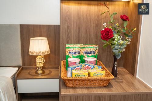 a basket of snacks on a table next to a lamp at Khách sạn MoonLight An Khánh Hà Nội in Vân Lũng