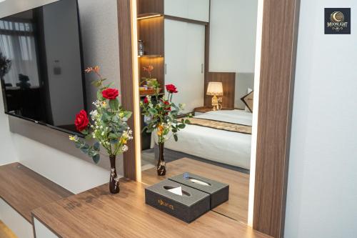 a hotel room with a bed and flowers on a table at Khách sạn MoonLight An Khánh Hà Nội in Vân Lũng