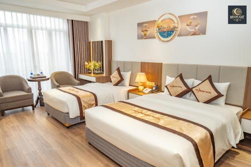 a hotel room with two beds and a chair at Khách sạn MoonLight An Khánh Hà Nội in Vân Lũng