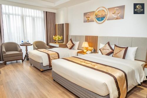 a hotel room with two beds and a chair at Khách sạn MoonLight An Khánh Hà Nội in Vân Lũng