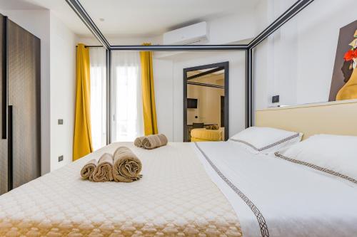 a bedroom with a large white bed with towels on it at Gatto Matto in Brolo