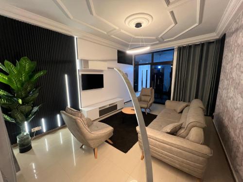a living room with a couch and chairs and a tv at CATU Colors and Comfort, A Choice of Studios in Dakar in Dakar