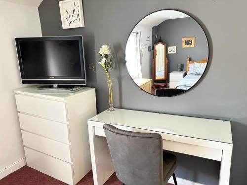 a white desk with a television and a mirror at Llanidloes Townhouse-pet-friendly-sleeps 7-Mid Wales in Llanidloes