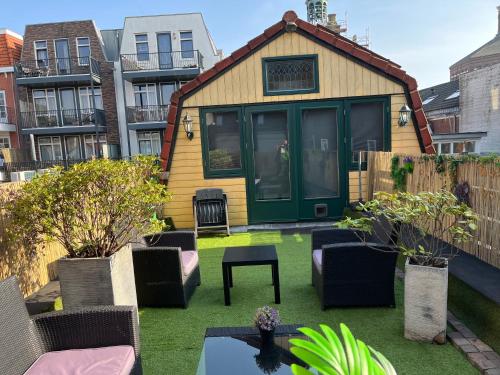 a small house with a green door on a yard at Comfortabel studio 19 min from downtown Amsterdam in Purmerend
