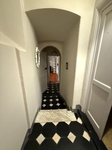 a hallway with a black and white checkered floor at Palazzo Cambiaso Albergo Etico Genova in Genova