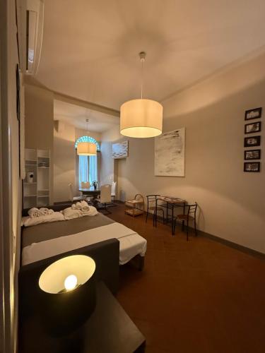 a room with two beds and a table and a window at Palazzo Cambiaso Albergo Etico Genova in Genova