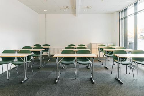 a row of tables and chairs in a room at St Svithun Hotel in Stavanger