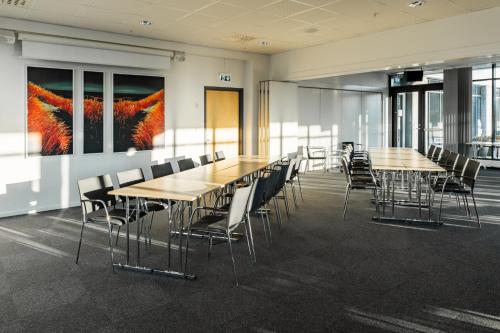 a conference room with wooden tables and chairs at St Svithun Hotel in Stavanger