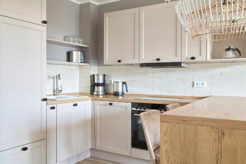 a kitchen with white cabinets and a counter top at Beach Apartments Büsum in Büsum