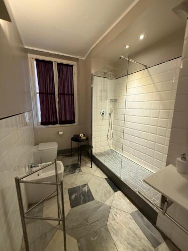 a bathroom with a shower with a glass door at Palazzo Cambiaso Albergo Etico Genova in Genova