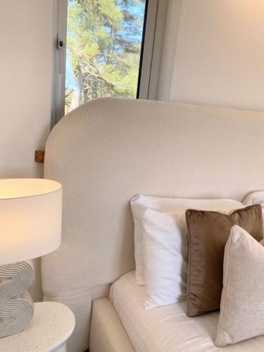 a white couch with pillows next to a window at Kaoglen - Alpine Pod - Hot Tub - Cairngorms - Pitlochry in Kirkmichael