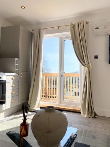 a living room with a large window with a view at Kaoglen - Alpine Pod - Hot Tub - Cairngorms - Pitlochry in Kirkmichael