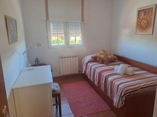 a small bedroom with a bed and a desk at El Mirador del Esla in Villanueva de las Manzanas