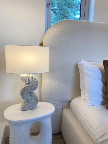 a lamp sitting on a table next to a bed at Kaoglen - Alpine Pod - Hot Tub - Cairngorms - Pitlochry in Kirkmichael