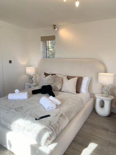 a large white bed in a room with two lamps at Kaoglen - Alpine Pod - Hot Tub - Cairngorms - Pitlochry in Kirkmichael