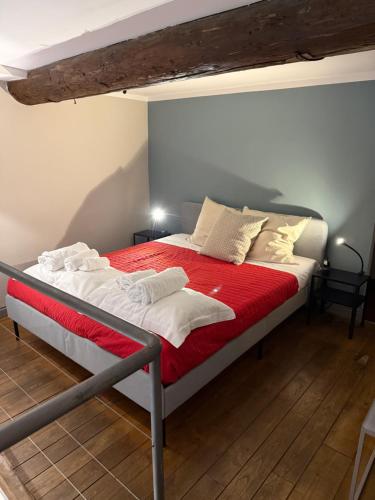 a bedroom with a bed with red sheets and white pillows at Palazzo Cambiaso Albergo Etico Genova in Genova