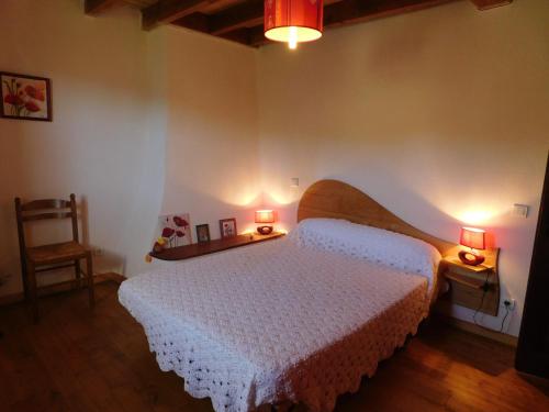 - une chambre avec un lit blanc et 2 lampes dans l'établissement Gite de France Lot Dordogne 3 épis, à Saint-Vincent-du-Pendit