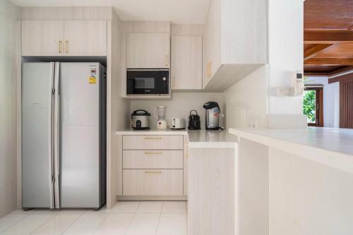 a kitchen with white cabinets and a refrigerator at Thai Villa Melitta Bangrak Bohput, Beach, Pool, SeaViews, 6-enSuite, Full Villa, Luxury, AAA Location Koh Samui in Bang Rak Beach