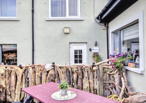 a table in front of a house with a fence at Thistle Apartment Golspie in Golspie