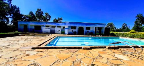 a swimming pool in front of a house at Malava-K-Resort in Kakamega