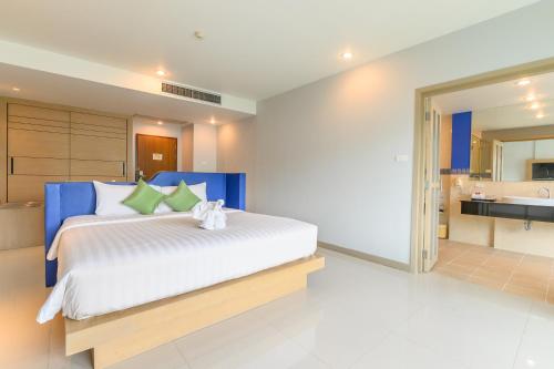 a bedroom with a large bed and a bathroom at Andakira Hotel - SHA Extra Plus in Patong Beach