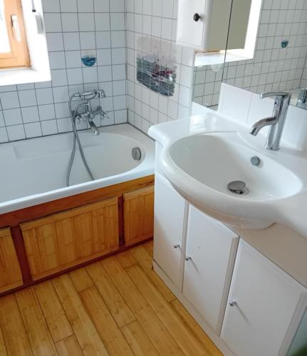 une salle de bain avec un lavabo et une baignoire dans l'établissement Le vieux logis, à Le PARC