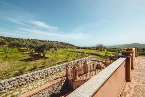 a balcony with a stone wall and a field at Case vacanze Torrerusso in Casa Pupo