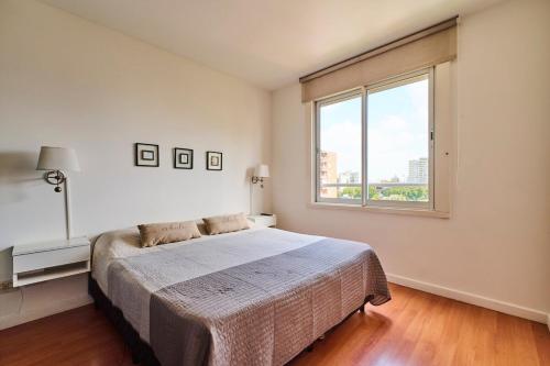 a bedroom with a bed and a large window at Ayres de Nuñez 5 stars in Buenos Aires