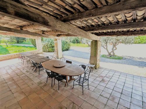 une table et des chaises en bois sur une terrasse dans l'établissement Maison 3 chambres, calme absolu, piscine, tennis, parking, calanques, à Roquefort-la-Bédoule