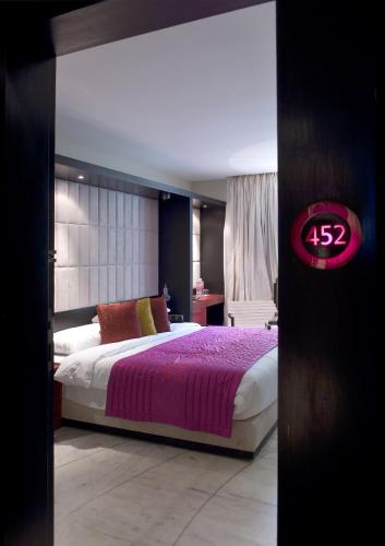 a bedroom with a large bed with a purple blanket at The Park Kolkata in Kolkata