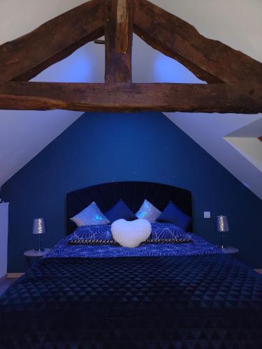 - une chambre bleue avec un lit doté d'un oreiller blanc dans l'établissement Le sensoriel, à Danvou