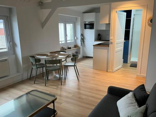 a living room with a table and chairs and a kitchen at Appartement Le POULIGUEN in Le Pouliguen