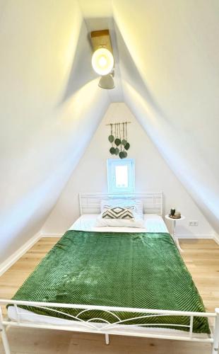a white bedroom with a bed in a attic at Lust auf Meer - Ferienwohnung für 4 Personen kleine Hunde willkommen Nähe Nordsee in Cuxhaven